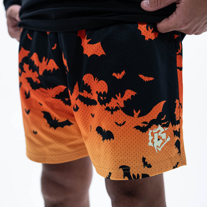 Adult model wearing orange shorts with "Bat Gradient" design