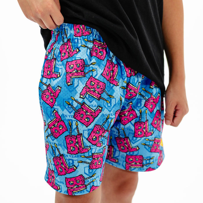 Youth model wearing blue youth shorts with "BL Birthday" design