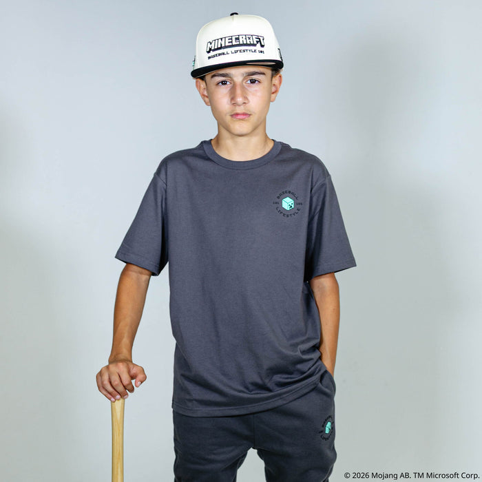 Youth model wearing gray youth graphic tee with "BL101 X Minecraft Athletics" design