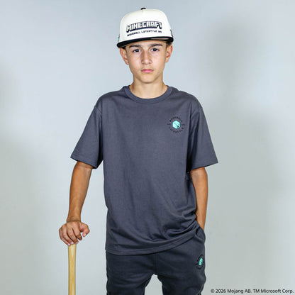 Youth model wearing gray youth graphic tee with "BL101 X Minecraft Athletics" design