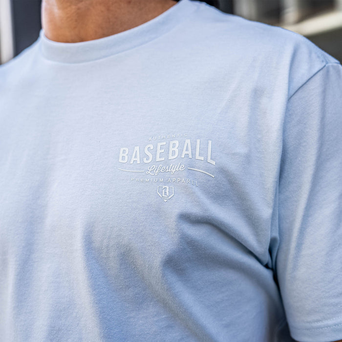 Light blue t-shirt with 'Authentic Baseball Lifestyle PREMIUM APPAREL' text on a person wearing it.