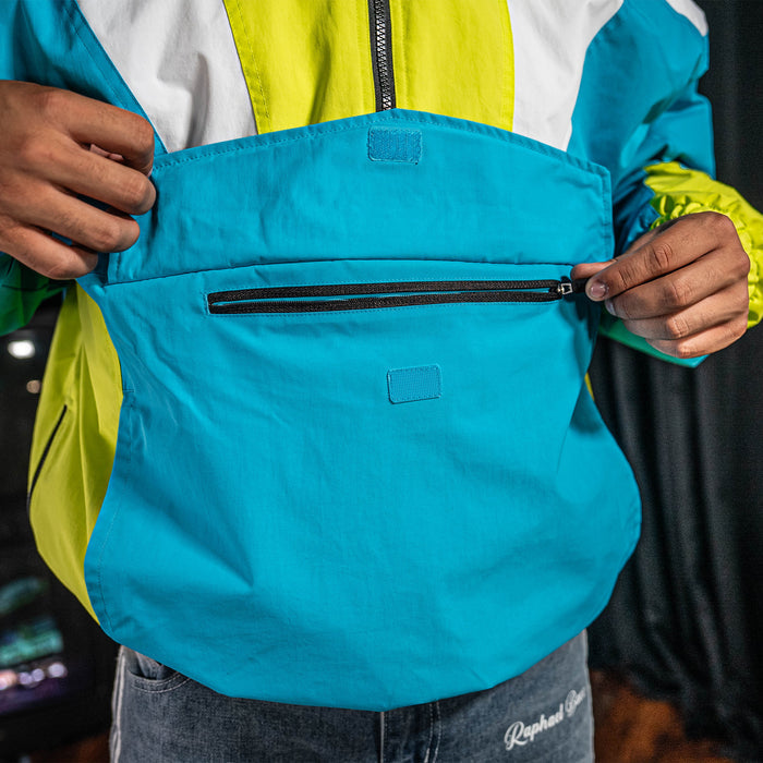 Person wearing a bright yellow, white and blue jacket.