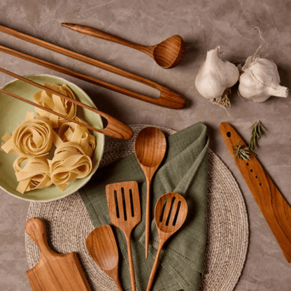 Teak sauce ladle among assortment of teak utensils