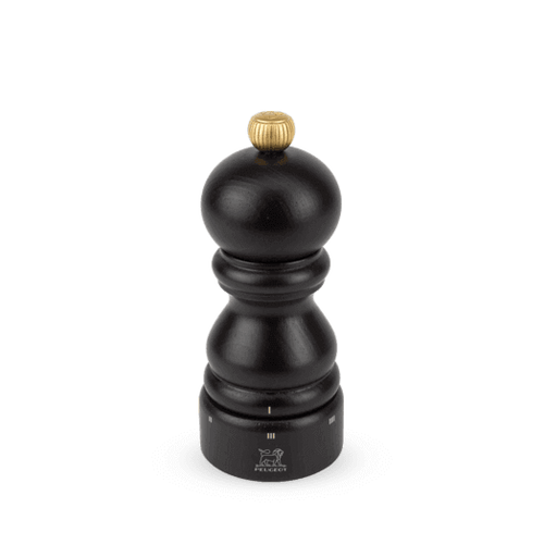 Dark brown pepper grinder with gold top on a whitet background